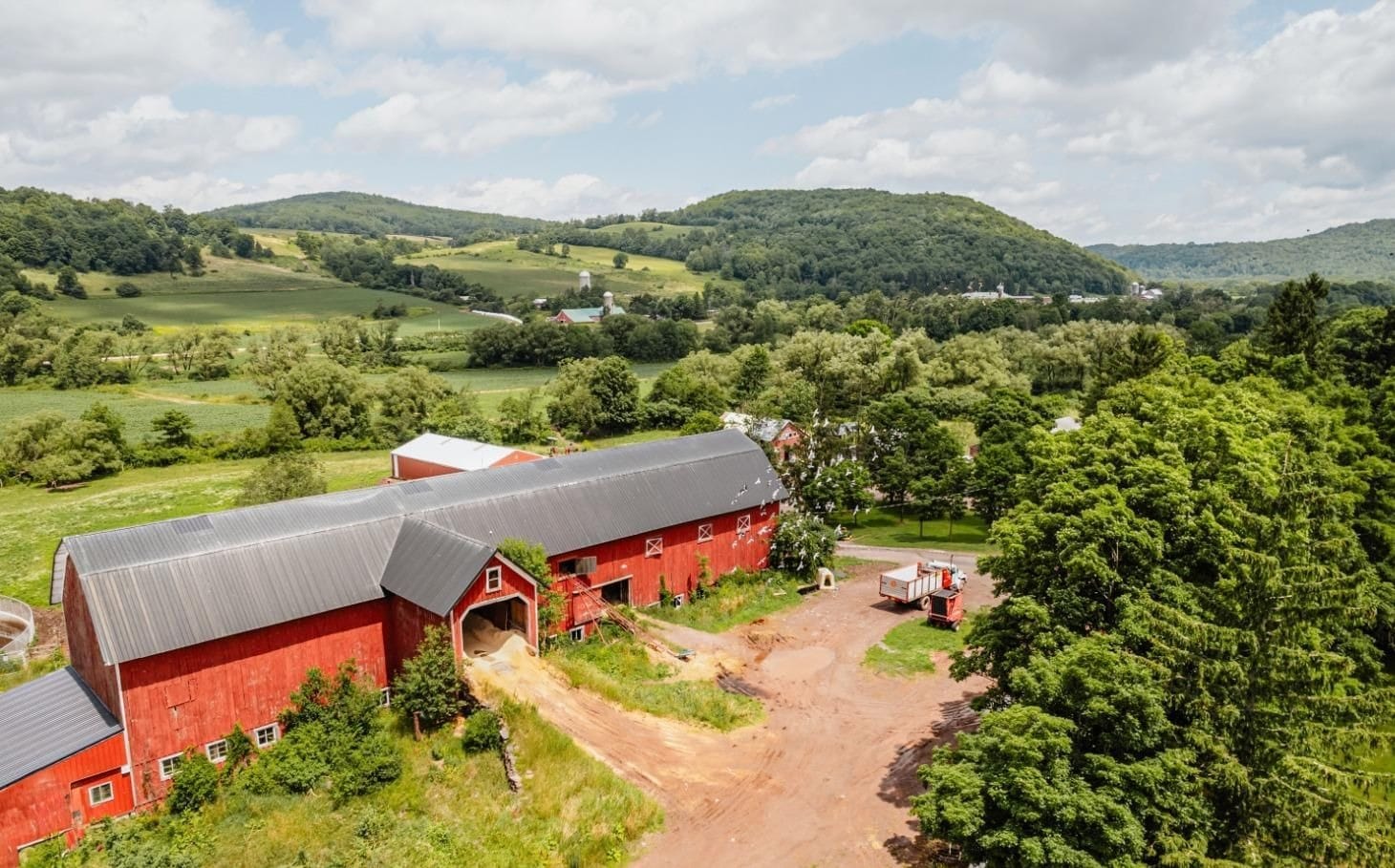 Ashridge red barn complex — aerial view with work yard and Catskill hills, South Kortright, New York