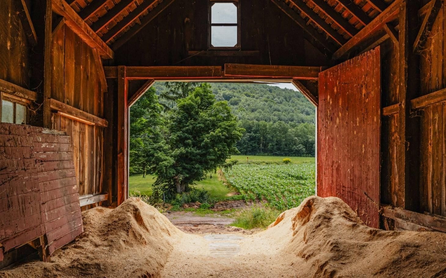 Ashridge barn interior — open doorway framing green fields, South Kortright, New York