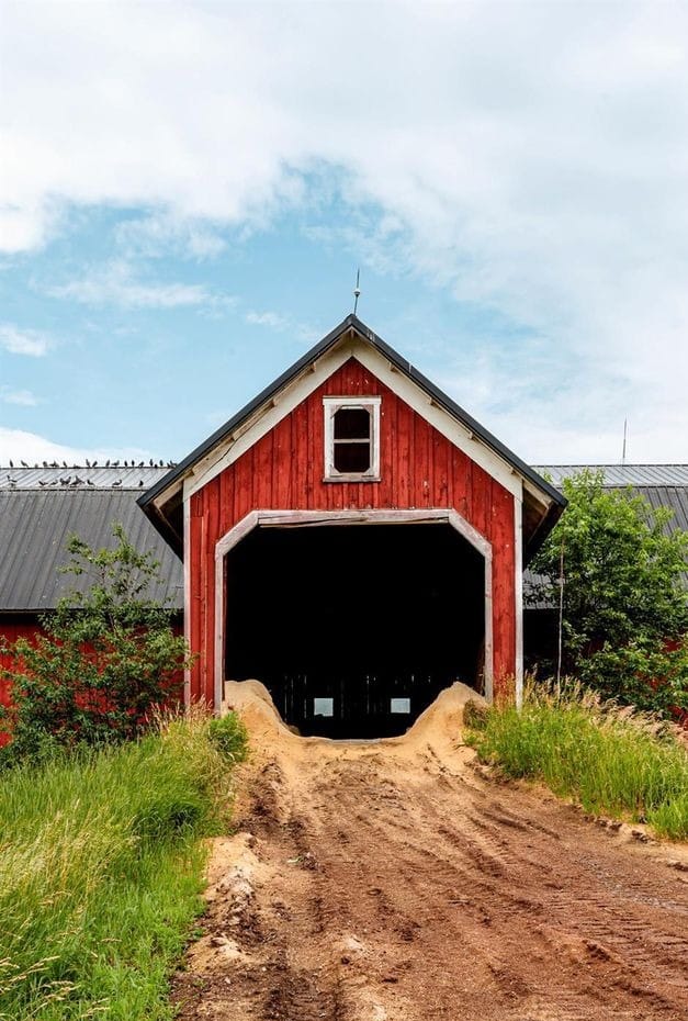 Ashridge red barn gable entrance — cut-stone foundation and dirt path, South Kortright, New York