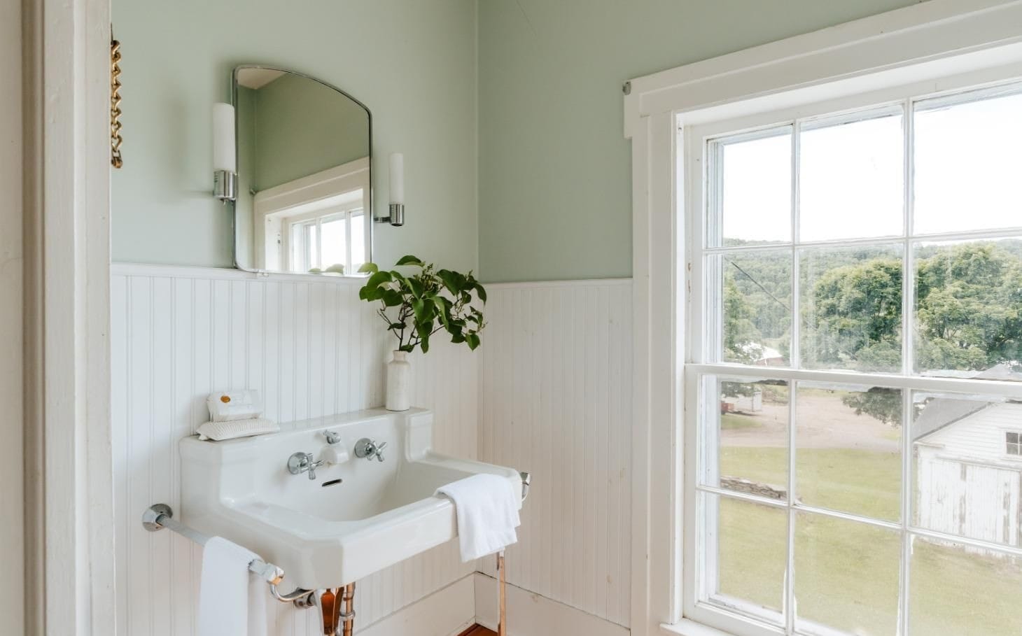 Farmhouse bathroom at Ashridge Estate — beadboard walls and wall-mount porcelain sink, South Kortright, New York