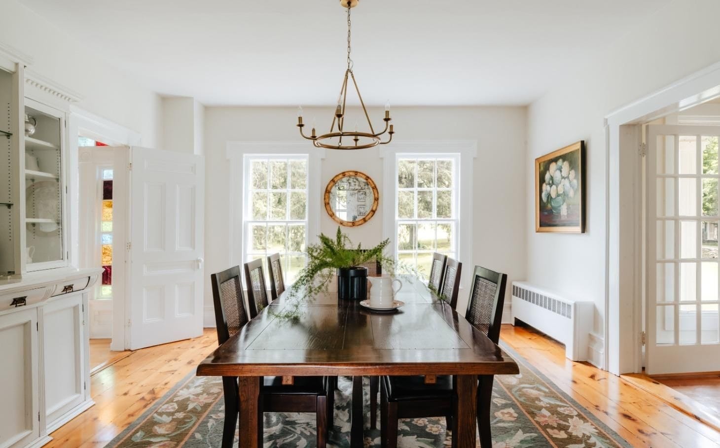 Farmhouse dining room at Ashridge Estate — long table, china hutch, and French doors, South Kortright, New York