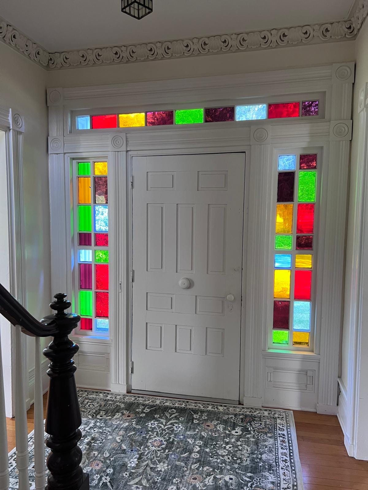 Farmhouse entry hall at Ashridge Estate — original hardwood floors and stained-glass transom windows, South Kortright, New York