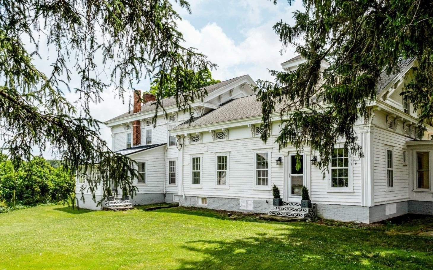 Greek Revival farmhouse side elevation — ornate brackets and brick chimney, South Kortright, New York
