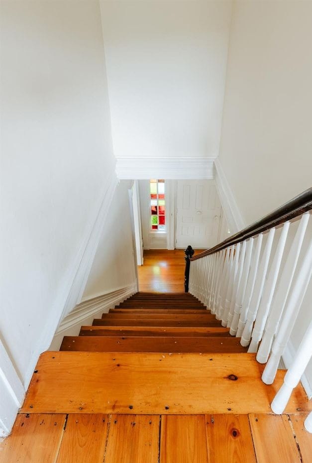 Farmhouse stair landing at Ashridge Estate — stained-glass transom window above the stairs, South Kortright, New York