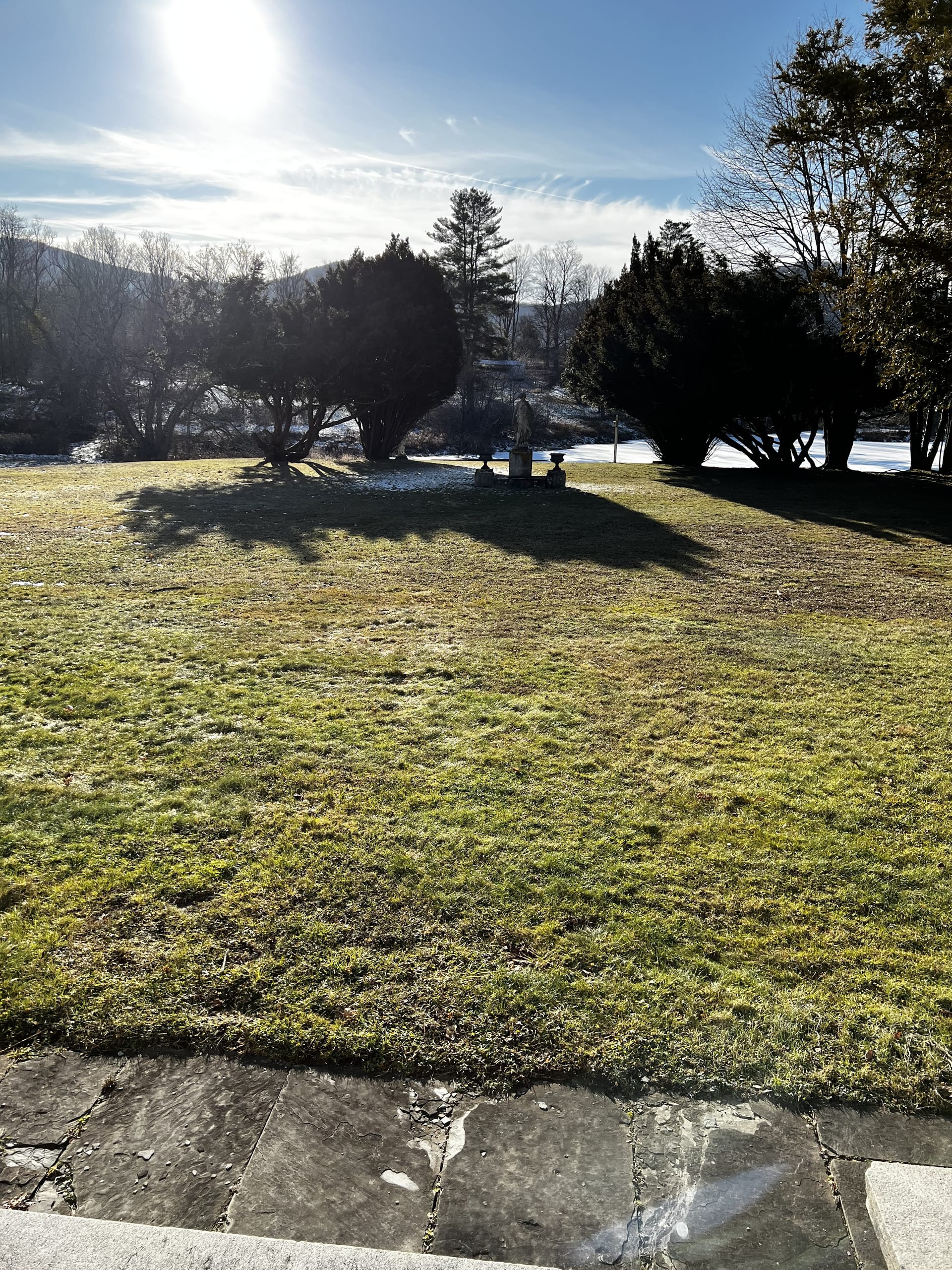 Ashridge estate grounds in winter — stone terrace, classical statuary, and snow-covered Catskills beyond