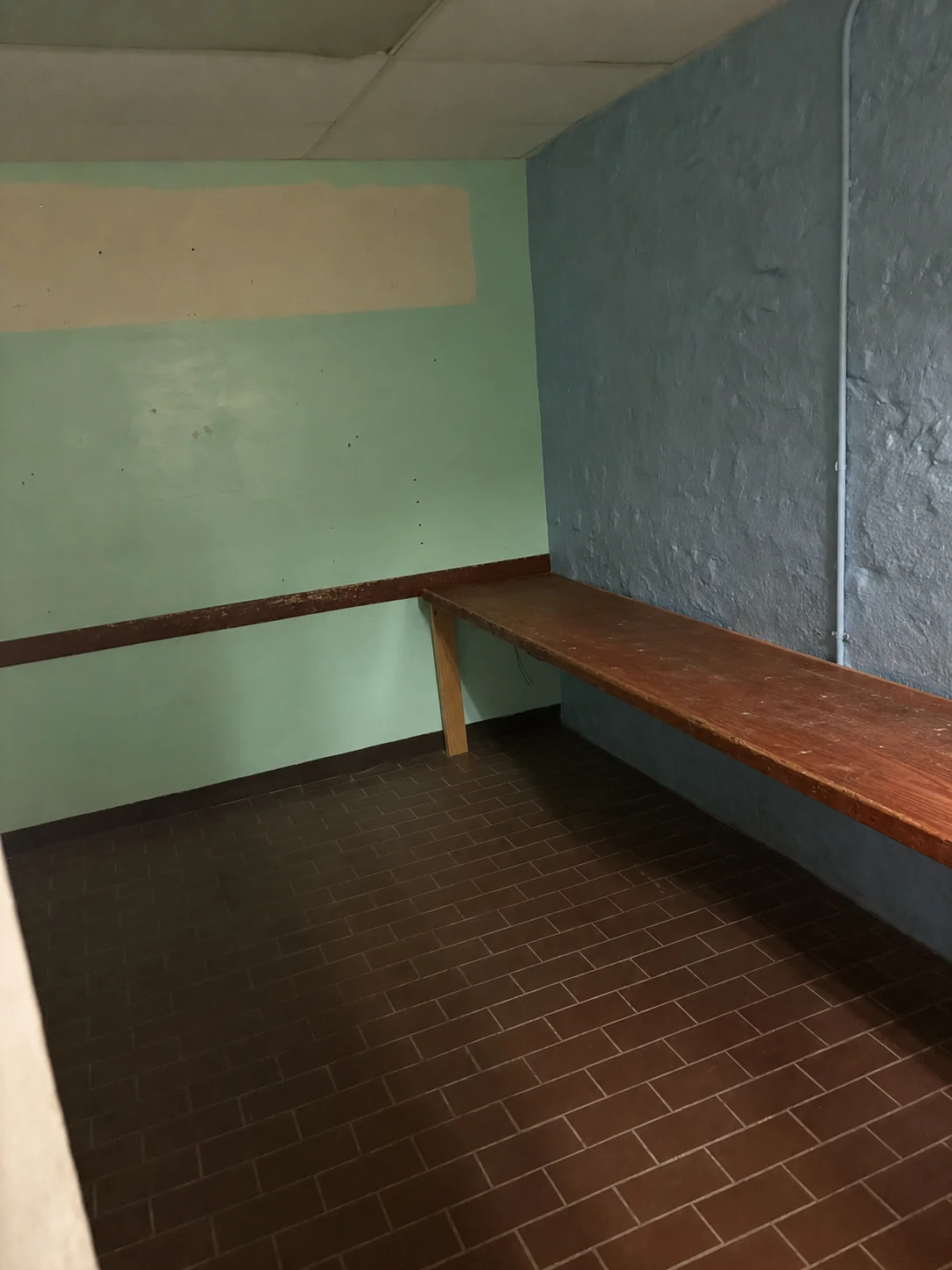 Two-tone mint and blue room with a long work bench and dark rail — mid-century institutional color (digitally cleared reference).