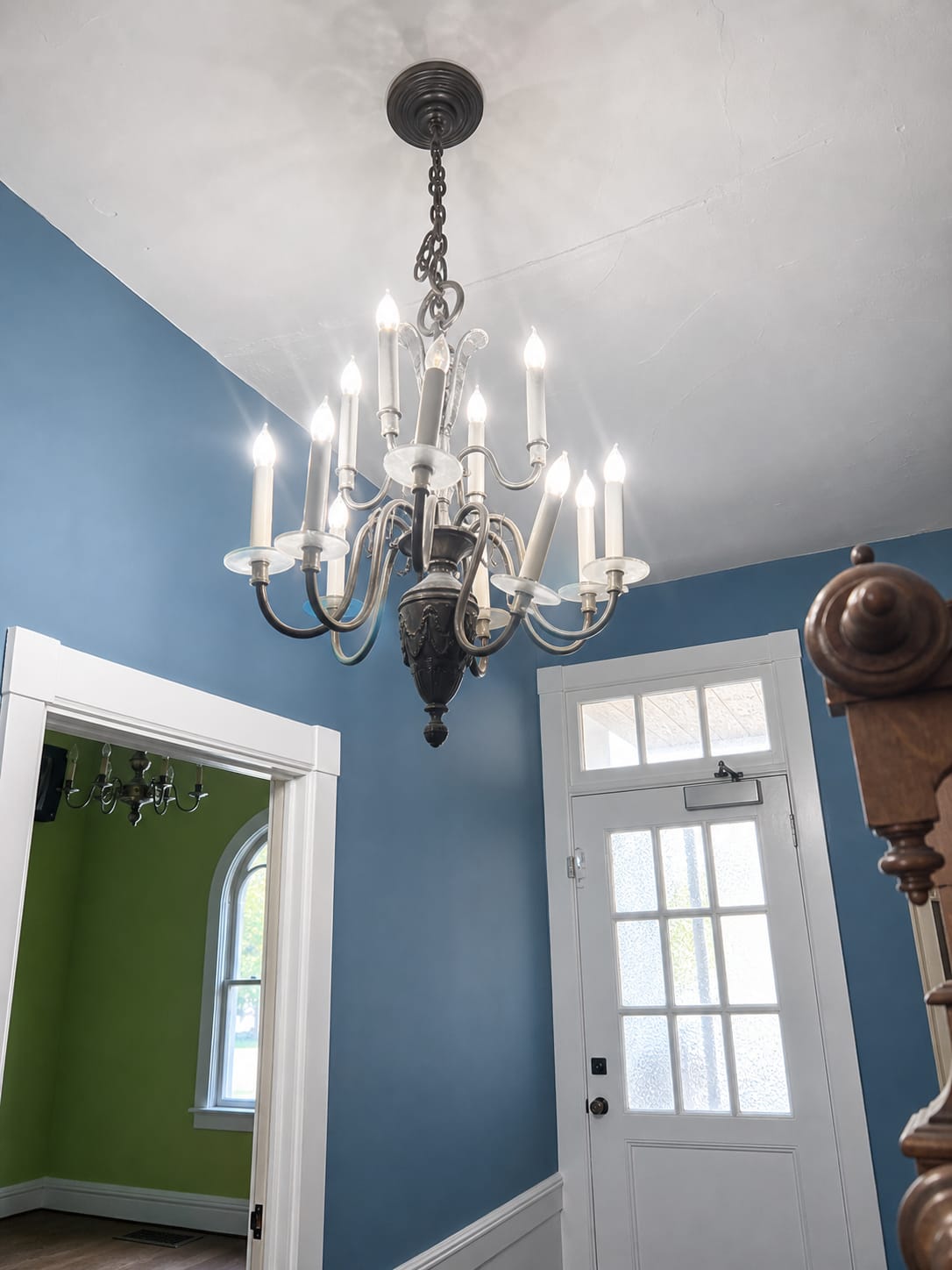 Ashridge mansion entry foyer — original front door with transom window and carved newel post